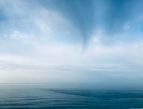 A tranquil ocean scene beneath a cloudy blue sky capturing serenity and calmness.