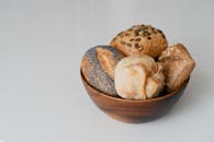 Assorted Bread Rolls in Wooden Bowl on White