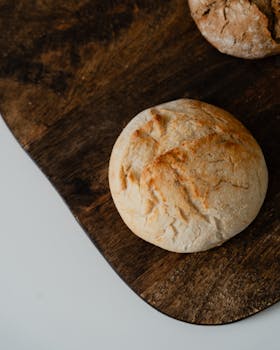 Two rustic artisan bread loaves on a wooden cutting board, perfect for culinary themes.
