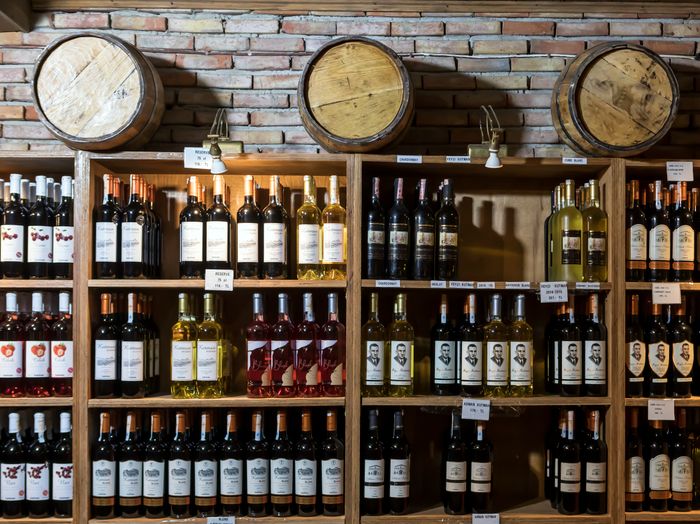 Cantina con bottiglie di vino e botti di legno