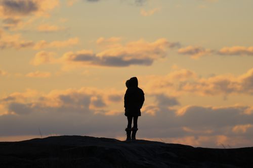 Free A solitary figure stands against a colorful dawn sky in Stamford, Connecticut. Stock Photo