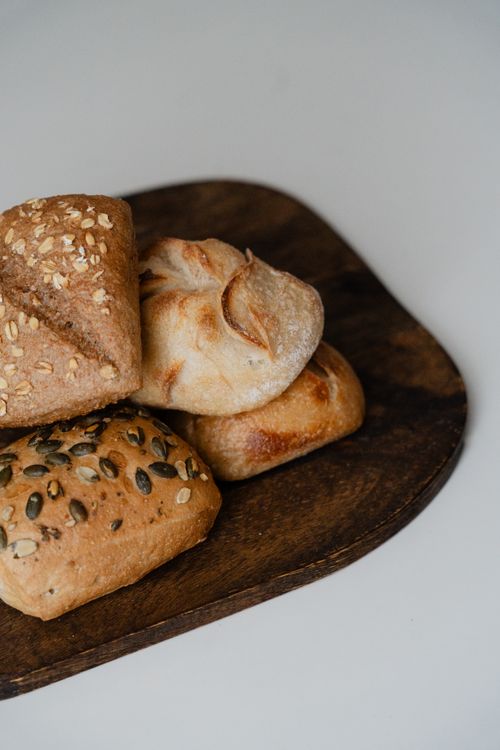 Free A variety of artisan breads with seeds and grains on a rustic wooden board. Stock Photo