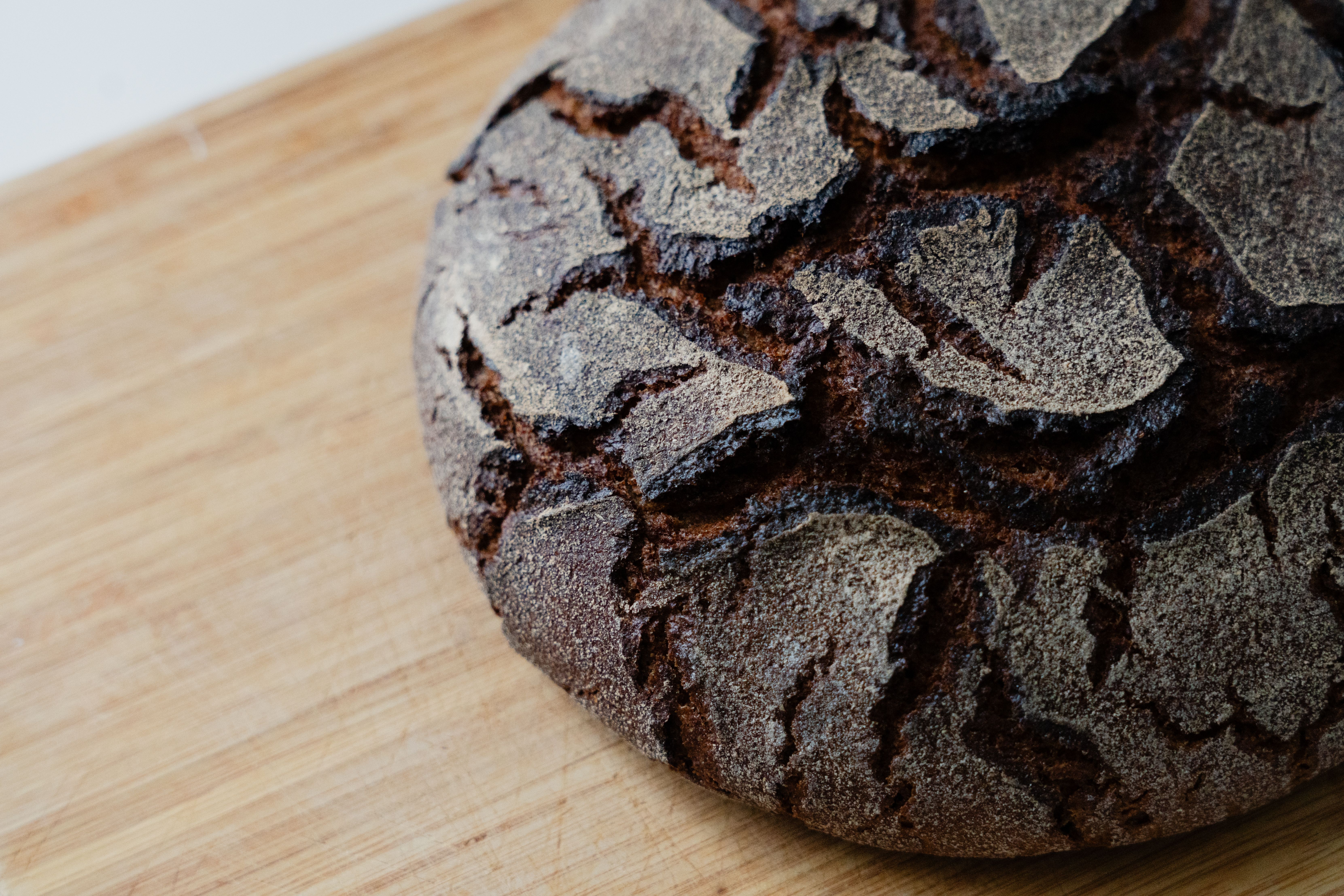 Crusty artisan sourdough loaf on a wooden cutting board.