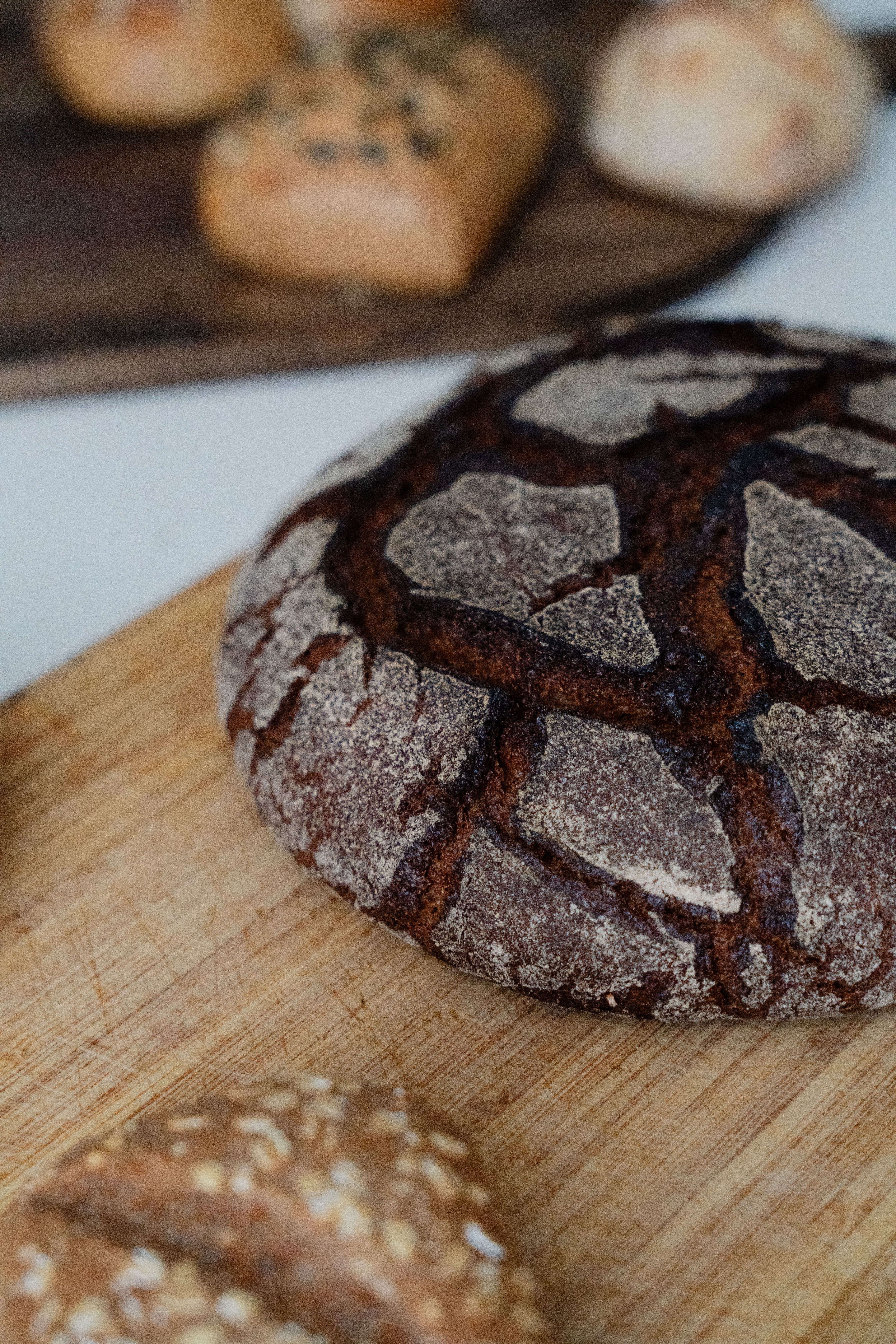 Close-up of various types of artisan bread on a wooden cutting board showcasing rustic textures.
