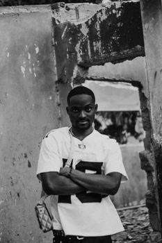 Black and white portrait of a man standing confidently with crossed arms.