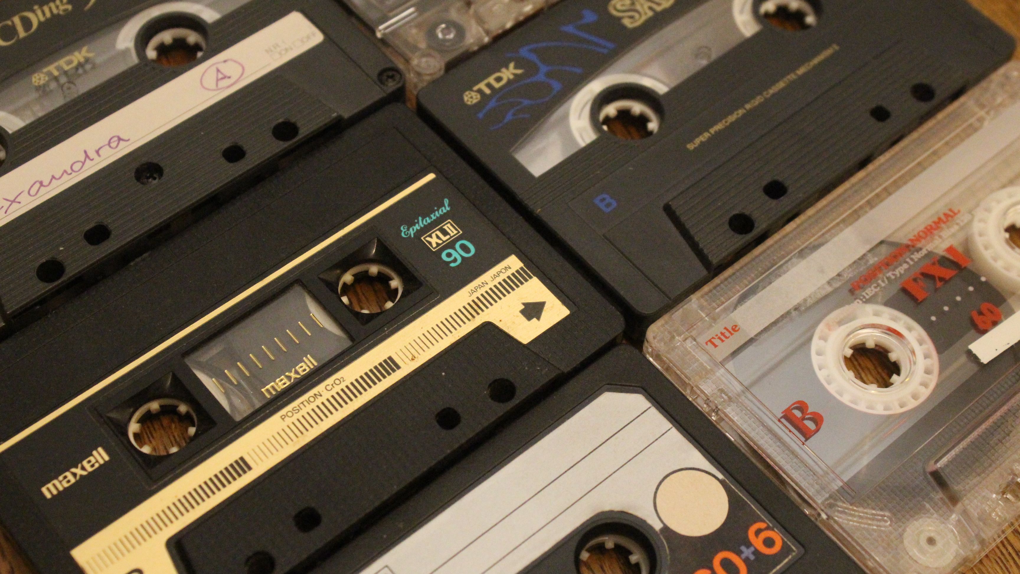 Assorted vintage audio cassettes stacked closely together showcasing retro audio media.