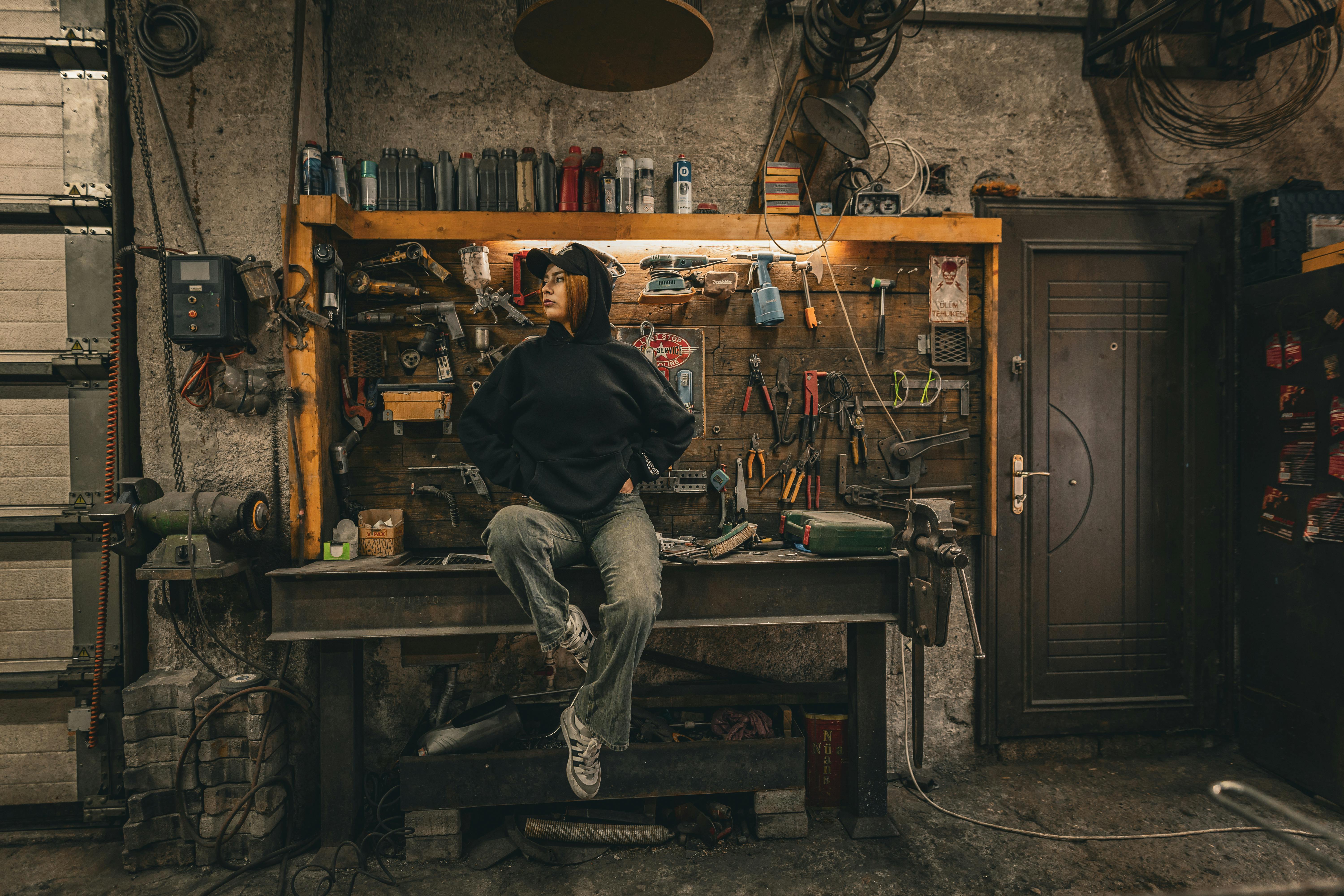 Young adult in an industrial workshop with tools, embracing urban lifestyle.
