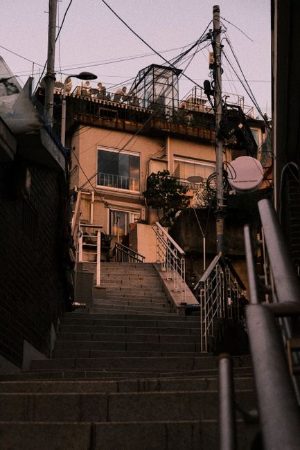 Twilight view of urban stairs leading to a typical Seoul neighborhood house.