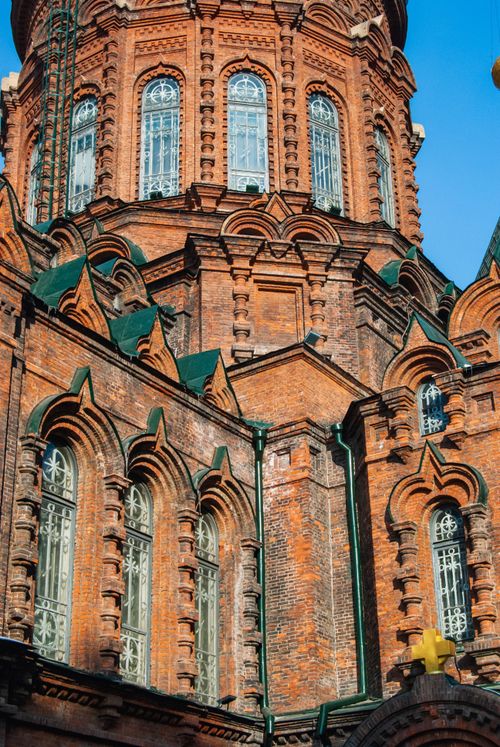 Free Close-up of a historic red brick chapel showcasing intricate Gothic architecture and large arched windows. Stock Photo