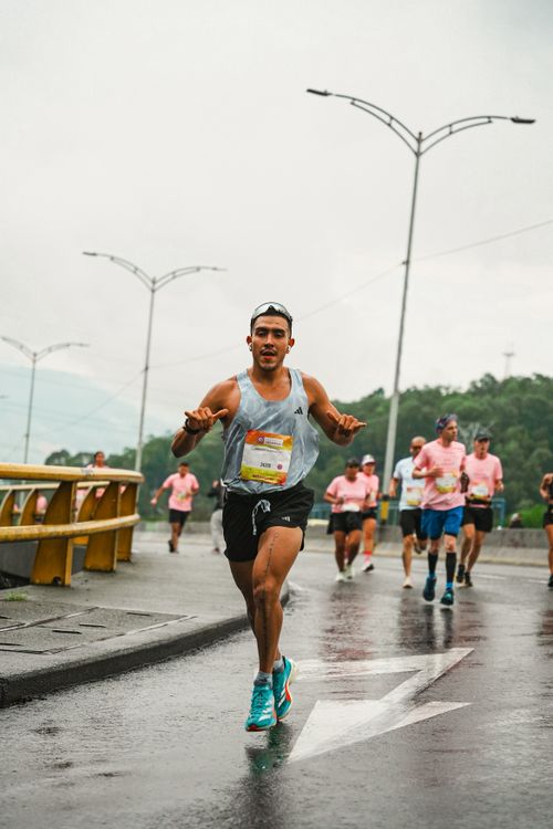 Free Group of athletes competing in a rainy urban marathon showcasing determination and teamwork. Stock Photo