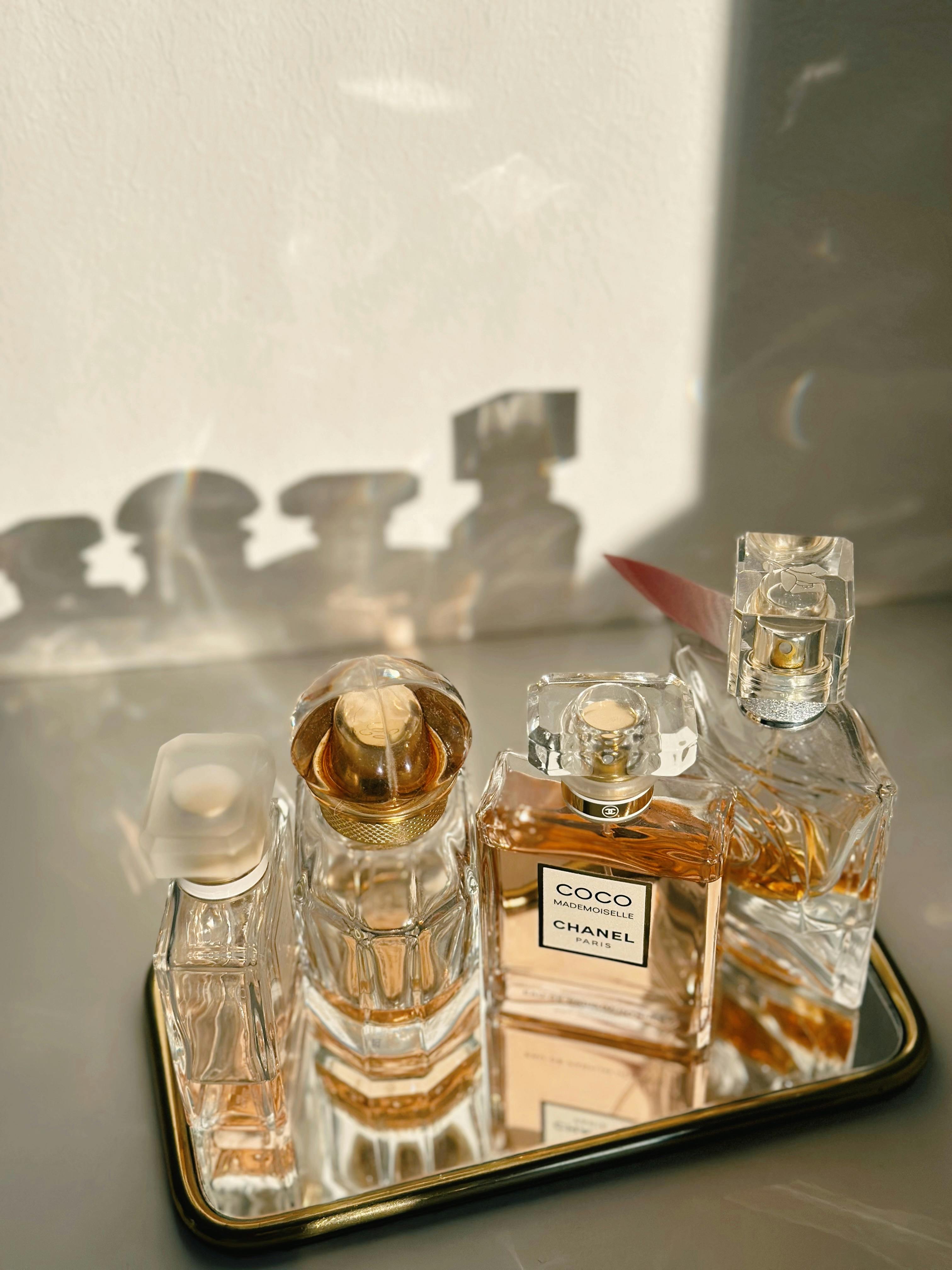 Luxurious assortment of Chanel perfume bottles with elegant shadows in warm lighting.