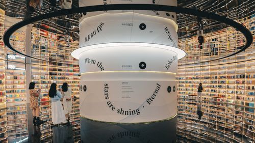 Free Futuristic bookstore interior in Shenzhen with mirrors and stylish lighting, attracting visitors to explore its vibrant book displays. Stock Photo