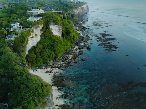 A breathtaking aerial view of lush cliffs and the serene coastline in Bali, Indonesia.