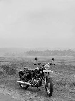 Black vintage motorcycle parked in a scenic Kerala landscape, India.