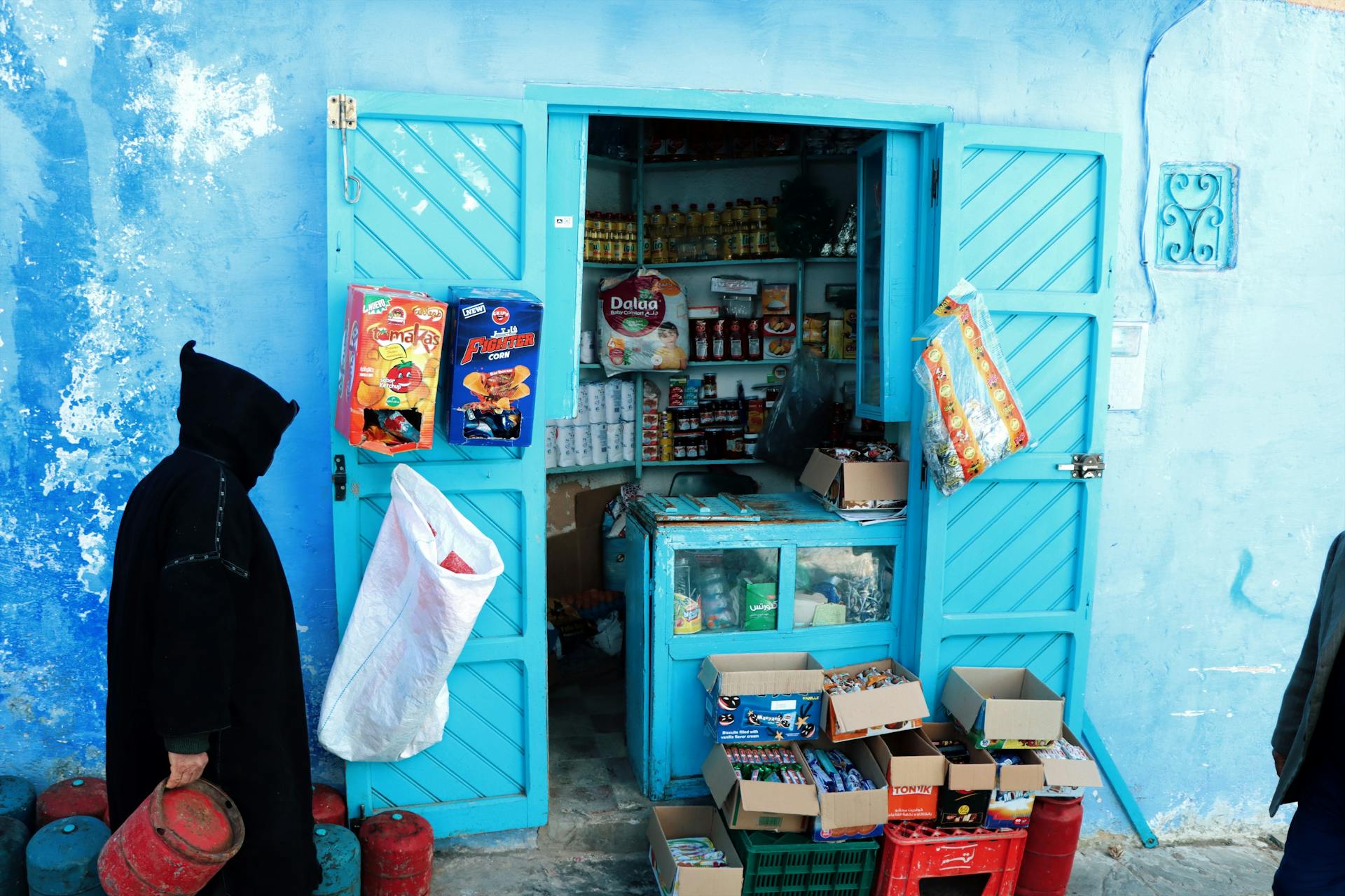 Colorful market stall with blue facade and assorted goods.