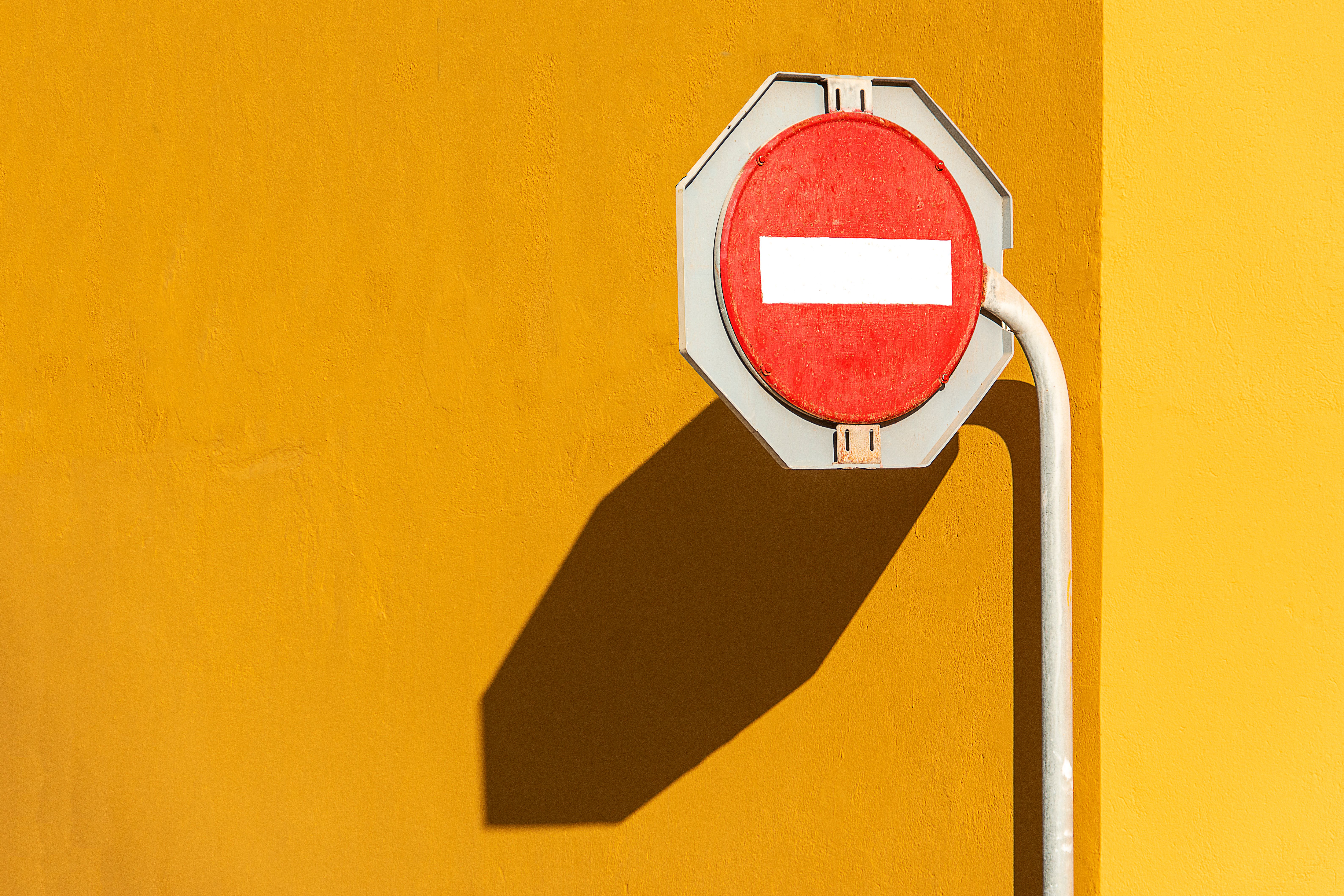 Vibrant Red and Yellow No Entry Sign on Wall