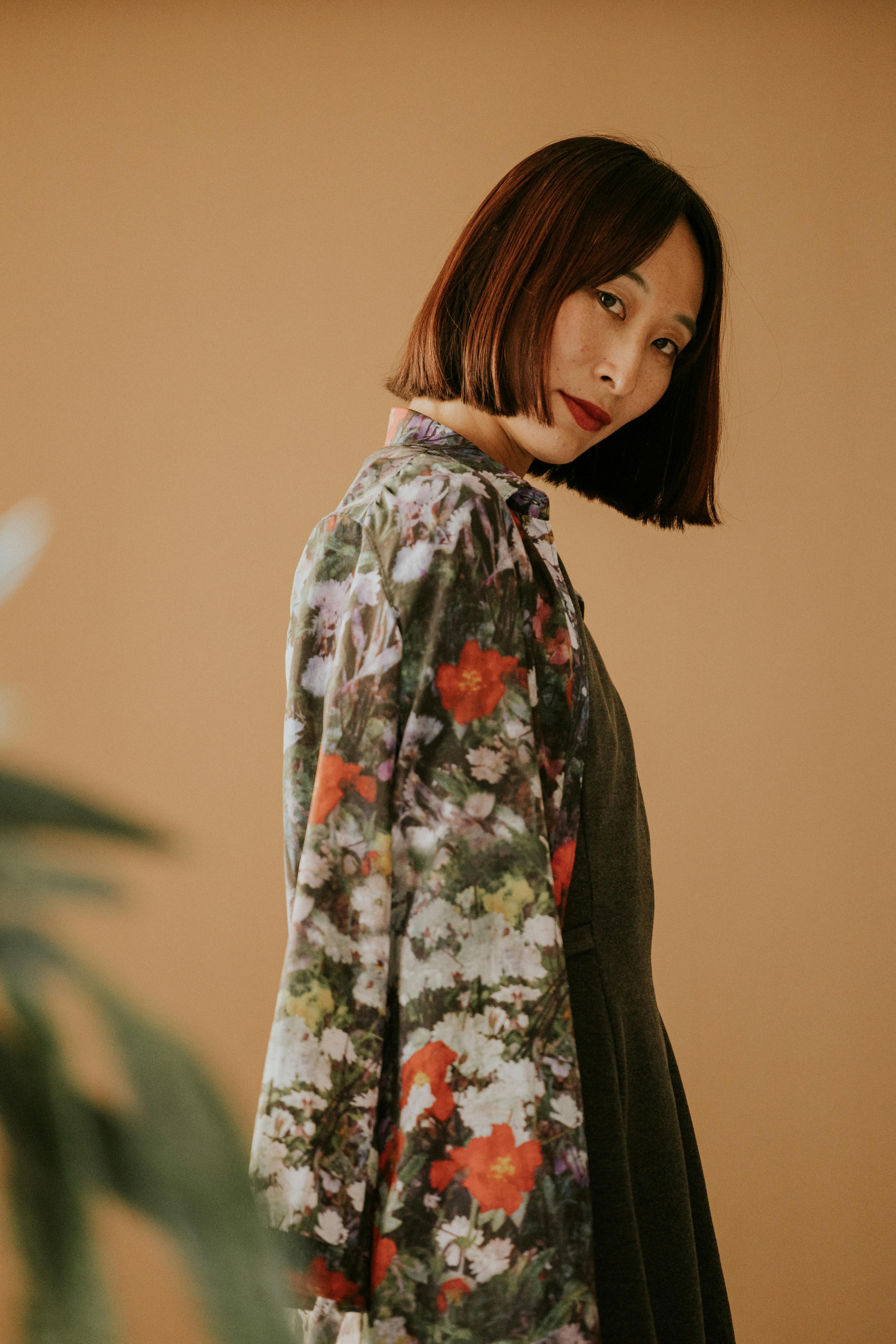 elegant woman in floral blouse on beige background