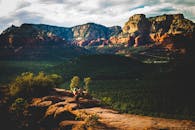 日落时分，一名女子在塞多纳壮丽的风景映衬下，于岩石壁架上表演瑜伽姿势