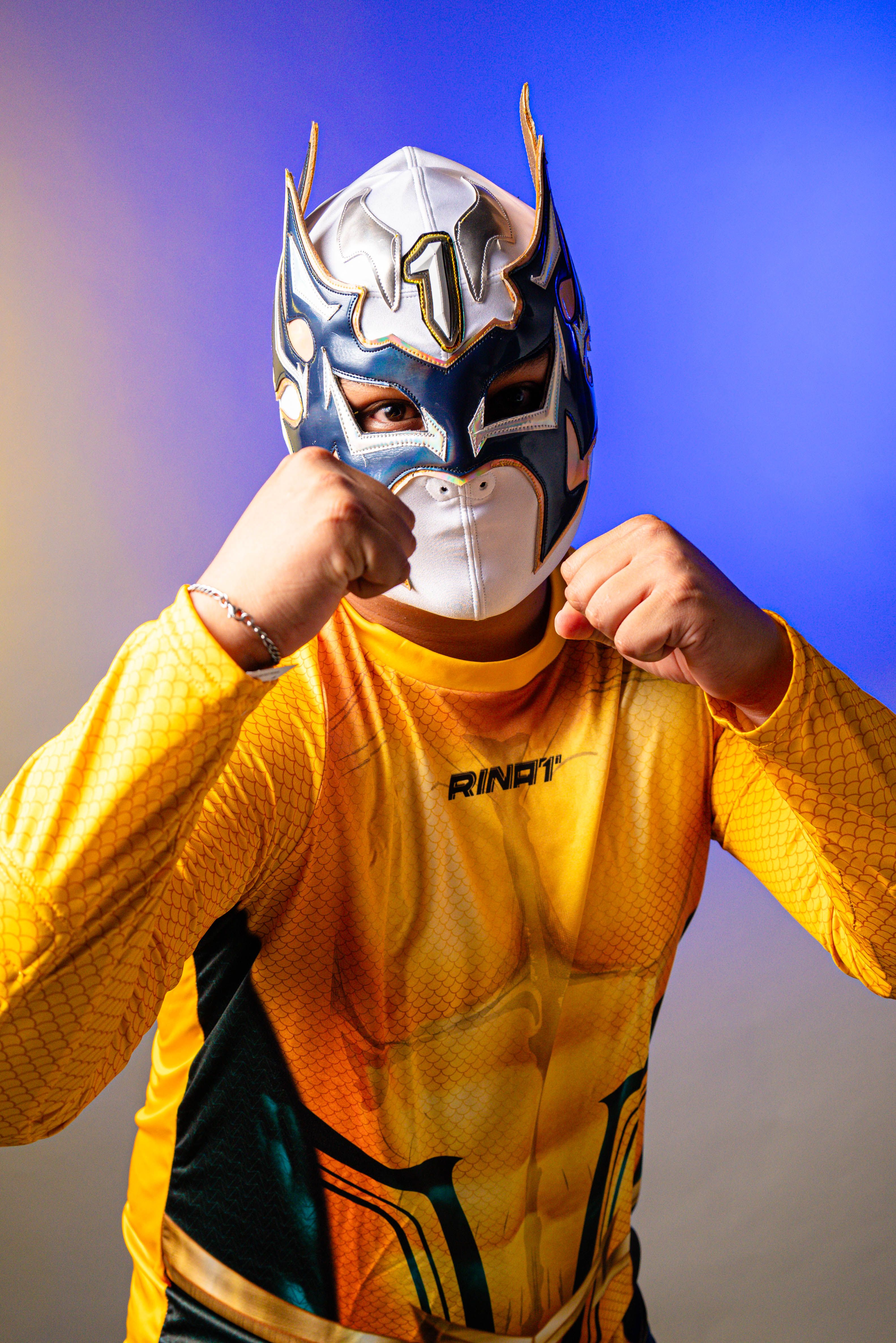 Luchador in vibrant costume strikes a pose, showcasing Mexican wrestling culture.
