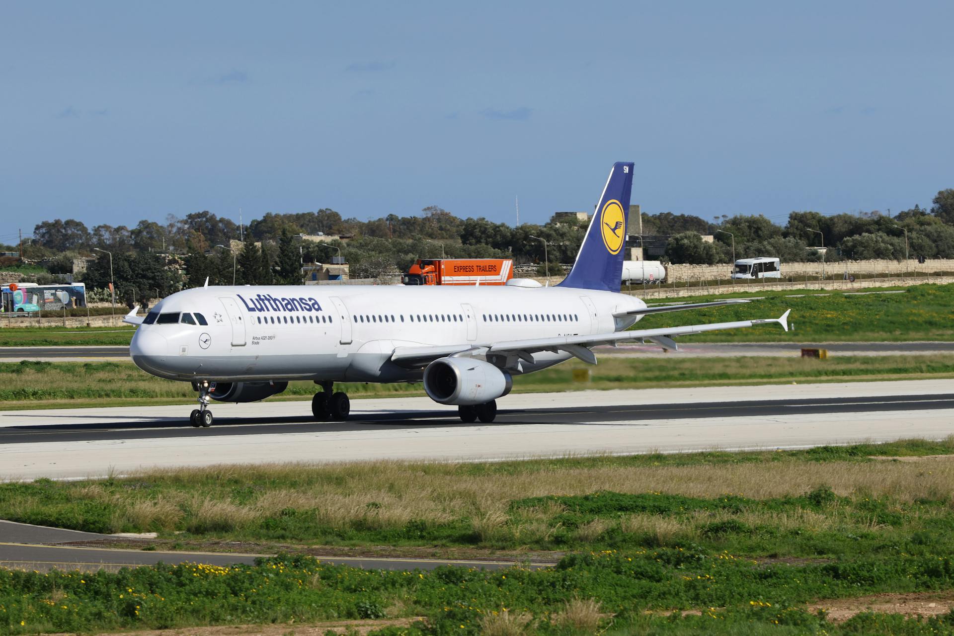 A Lufthansa airplane on the runway at an outdoor airport, ready for take-off.