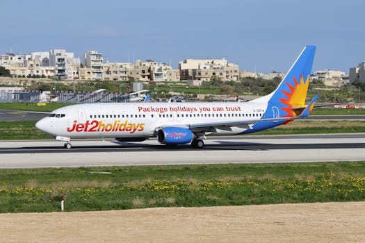 Jet2 Holidays Boeing 737 taxiing on runway with scenic city background.