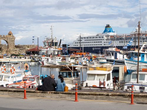Free A vibrant harbor scene featuring a cruise ship and various boats docked at a sunny waterfront. Stock Photo