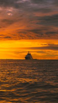 Spectacular view of a cruise ship sailing during a vibrant sunset in the Maldives.