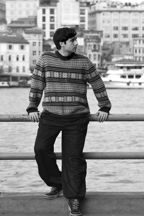 Free Black and white photo of a man in Istanbul near the waterfront, showcasing cityscape. Stock Photo