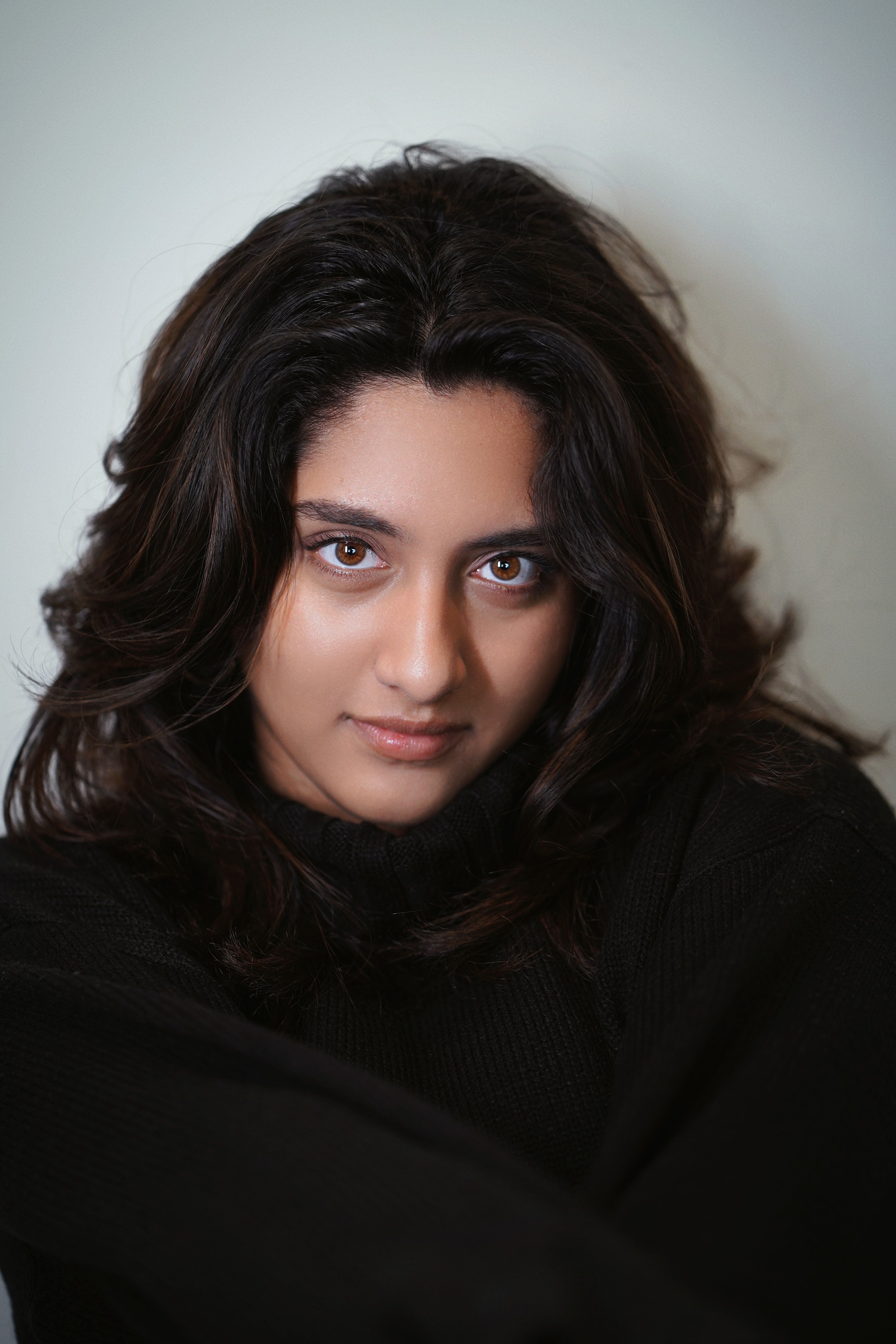 A close-up portrait of a young woman with dark hair and soft lighting.
