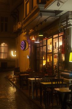 Charming street cafe in Istanbul with warm lighting on a rainy night.