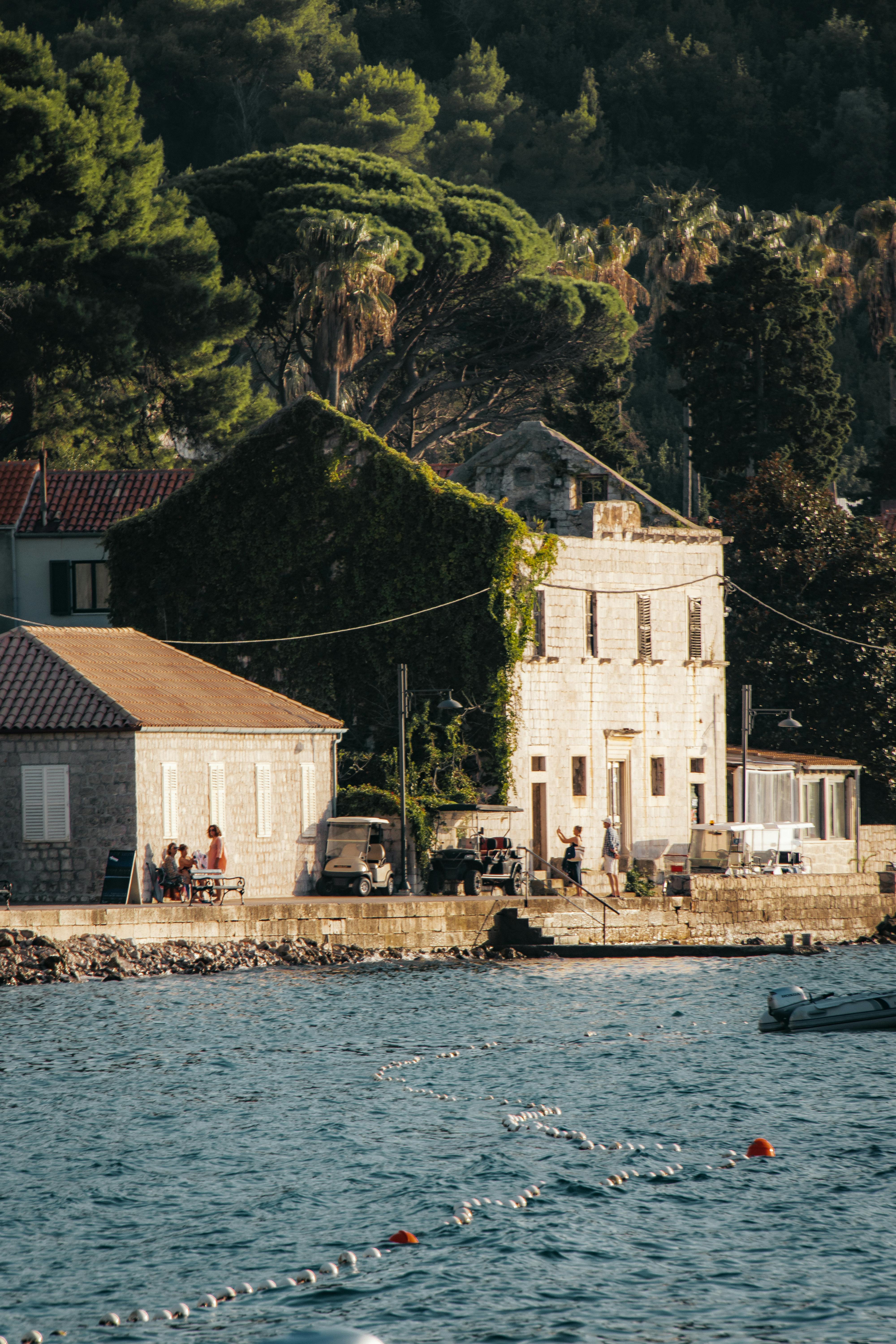 Charming coastal view of Lopud, Croatia with stone buildings and lush greenery.