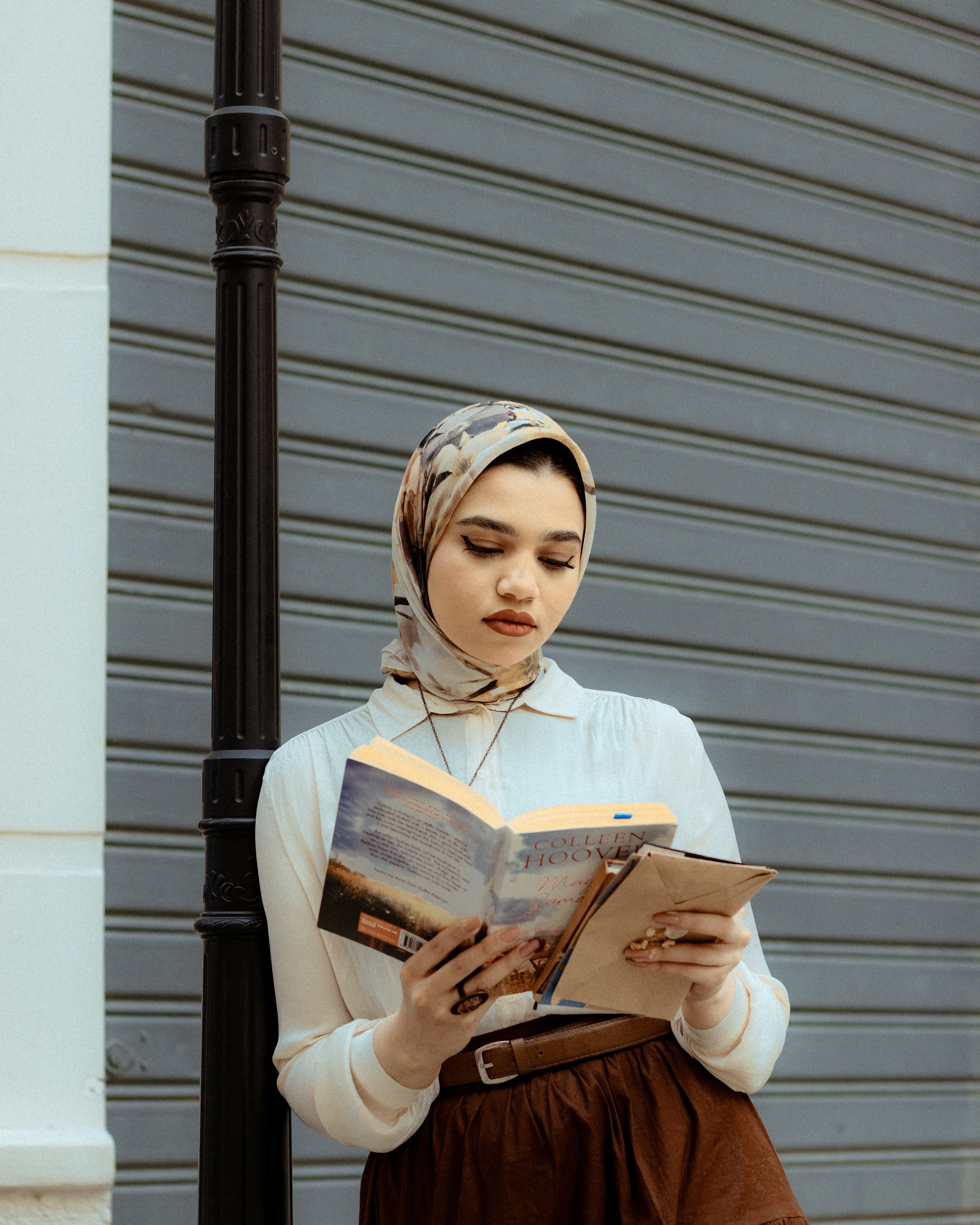 Young Woman Reading Book in a Hijab on Street · Free Stock Photo