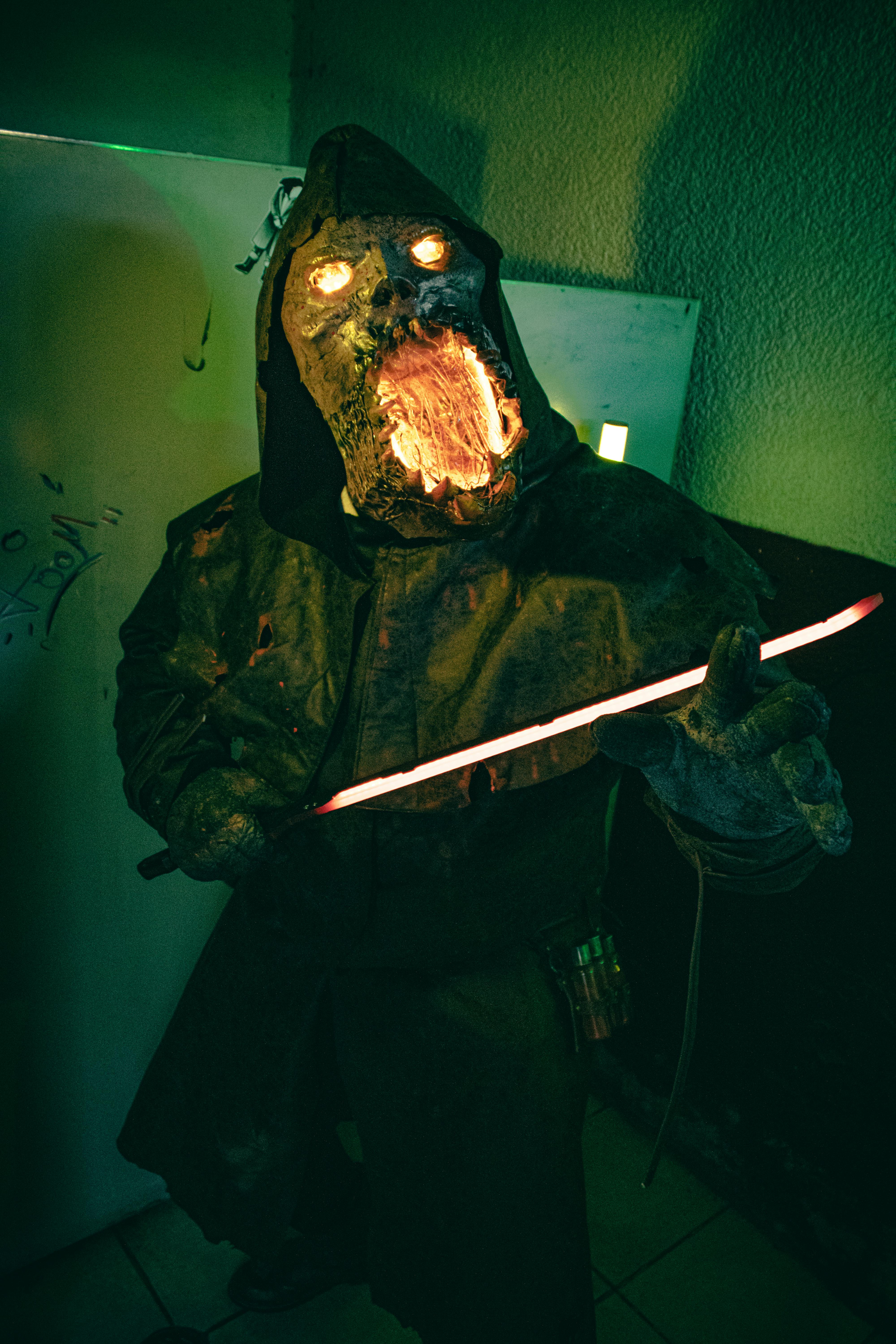 Eerie costume character with glowing eyes and mouth in a horror-themed cosplay.