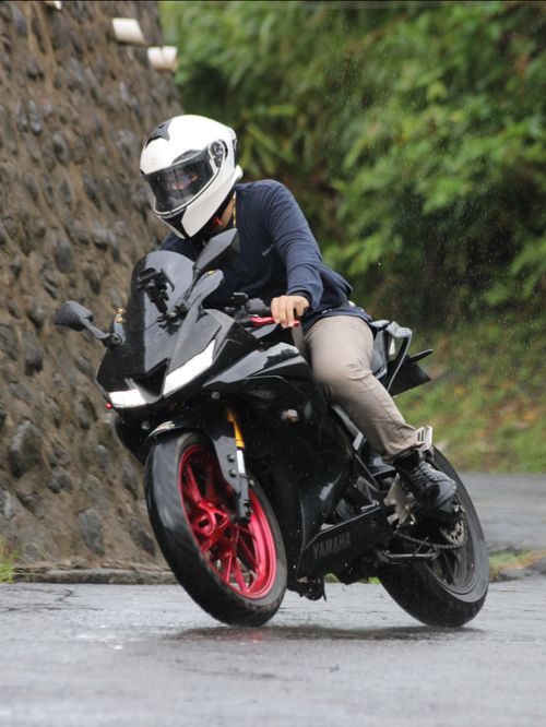 Free A motorcyclist in full gear navigating a sharp turn on a wet road. Stock Photo
