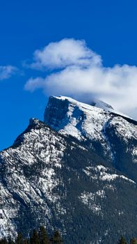 Stunning view of a snow-capped mountain peak under a clear blue sky in Banff National Park.