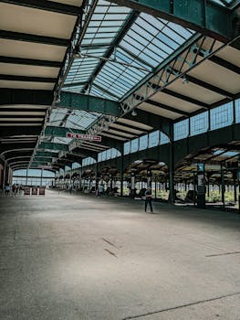 Spacious train station with vintage design and glass skylight roof.