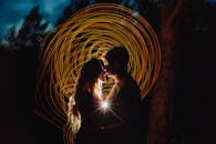 在夜间森林环境中，一对浪漫夫妇的剪影呈现出艺术光画效果