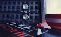 老式转盘的特写，上面有黑胶唱片和条纹碗