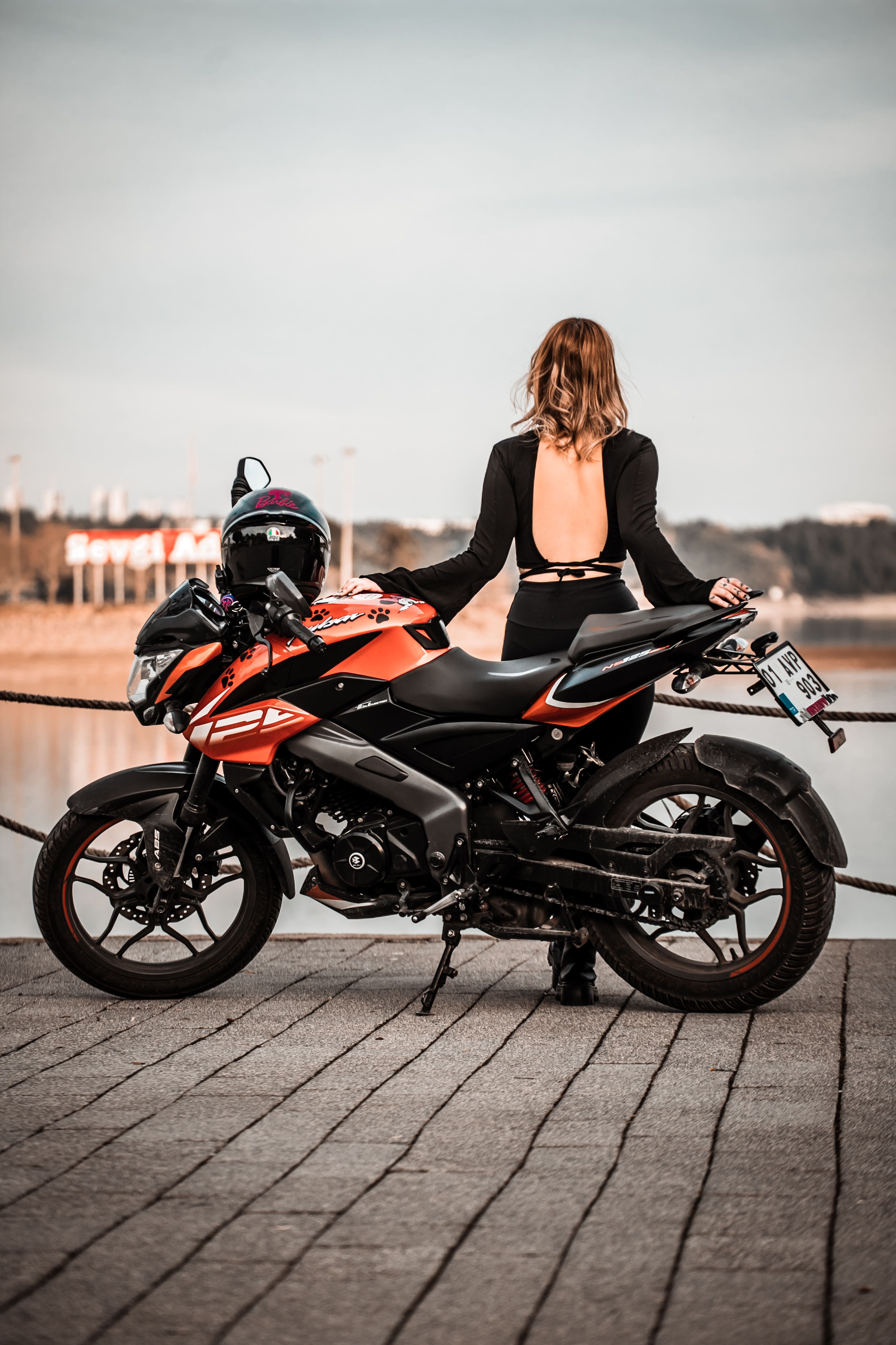 Woman on Motorcycle by Lake at Sunset · Free Stock Photo