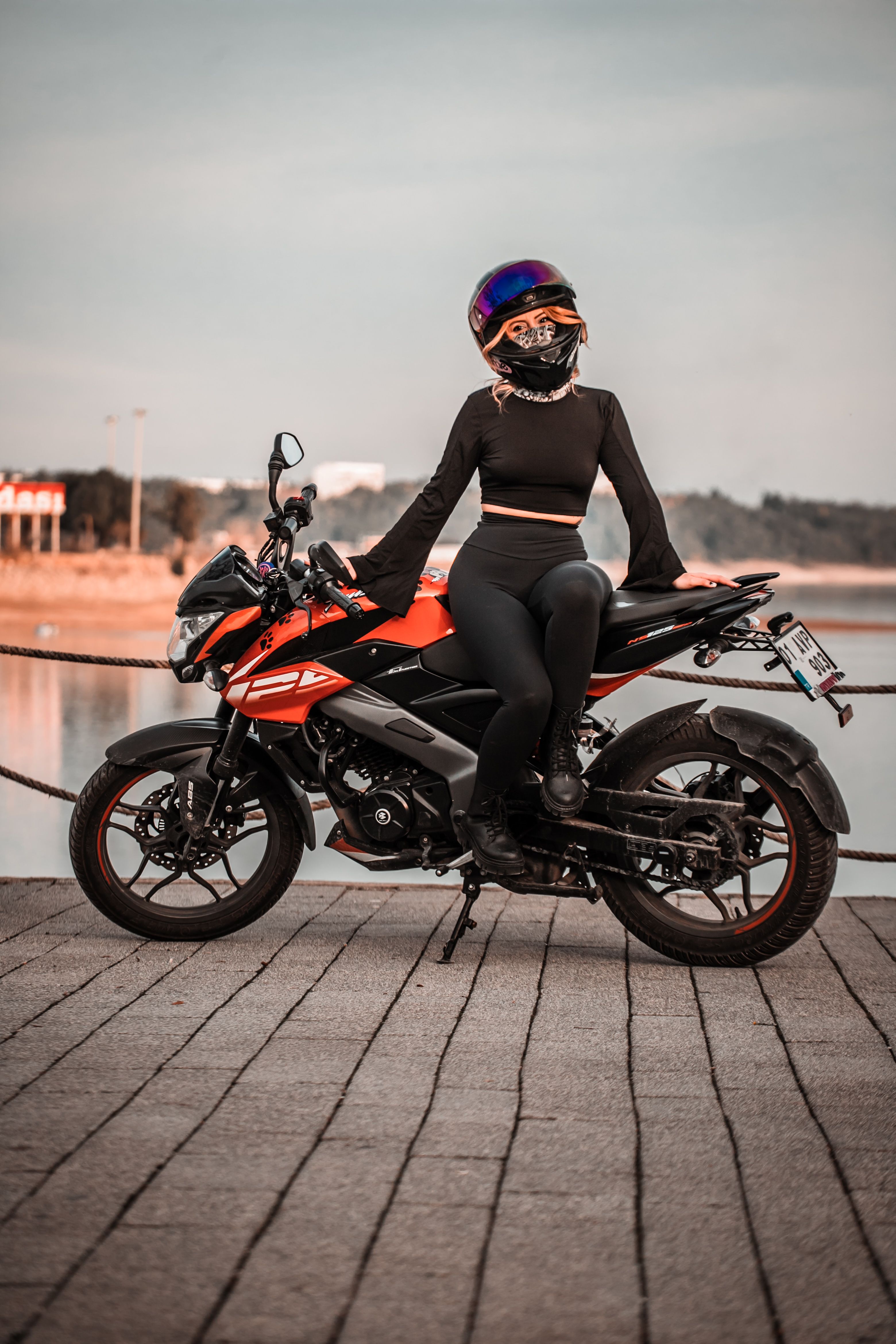Woman on Motorcycle by Lake at Sunset · Free Stock Photo