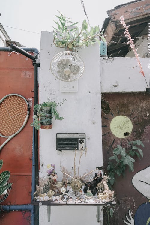 White Wall Fan Near Black Boombox