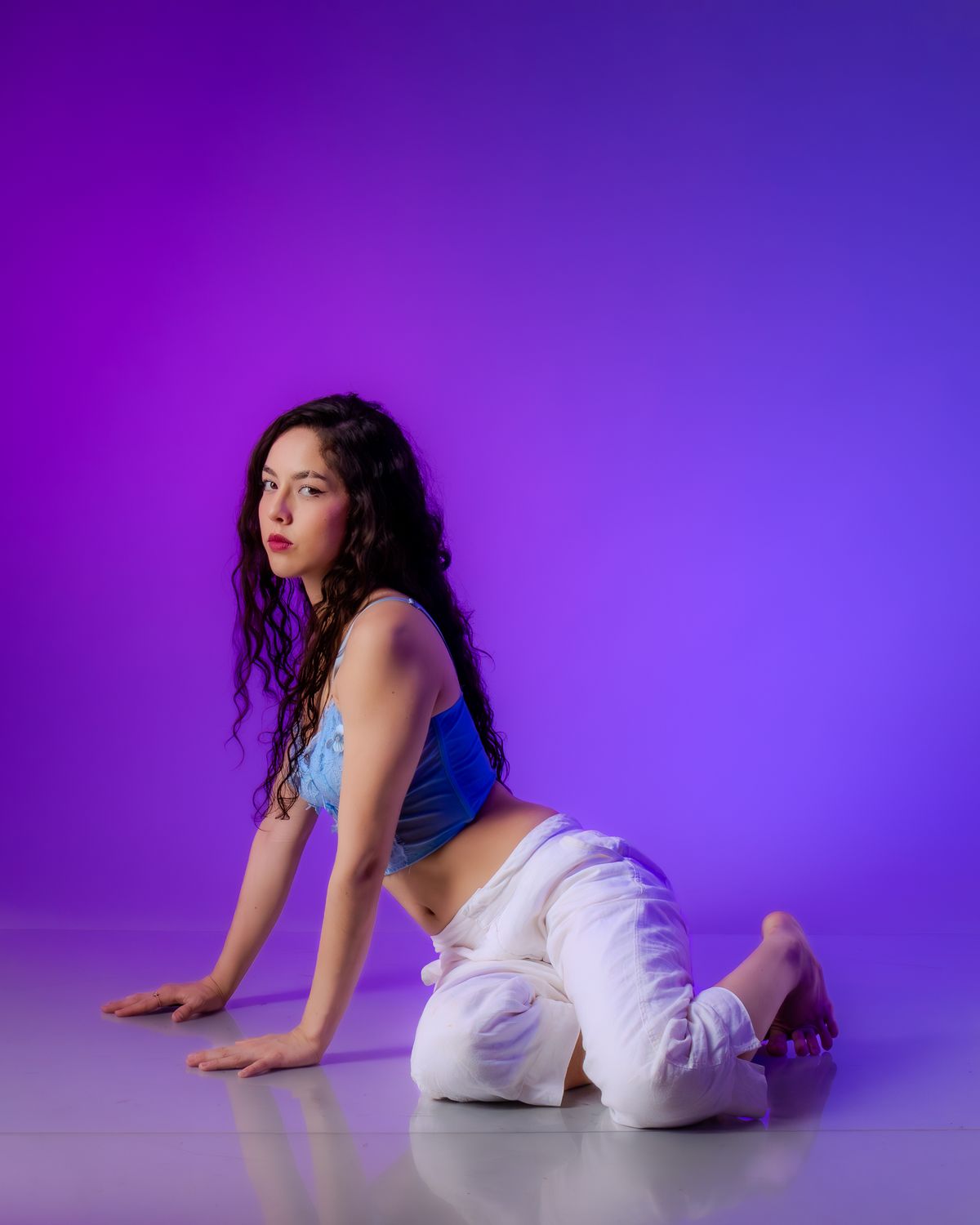 Talento femenino con pose expresiva y fondo violeta
