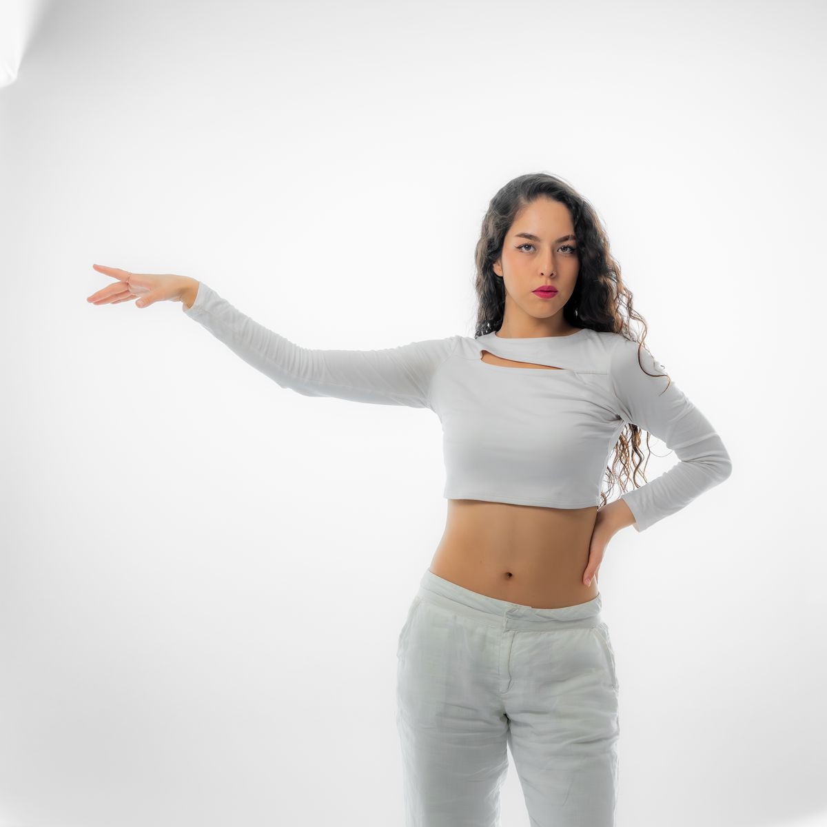 Model in a cropped knit top and light trousers on a white studio backdrop — photo by Jimmy Elizarraras on Pexels