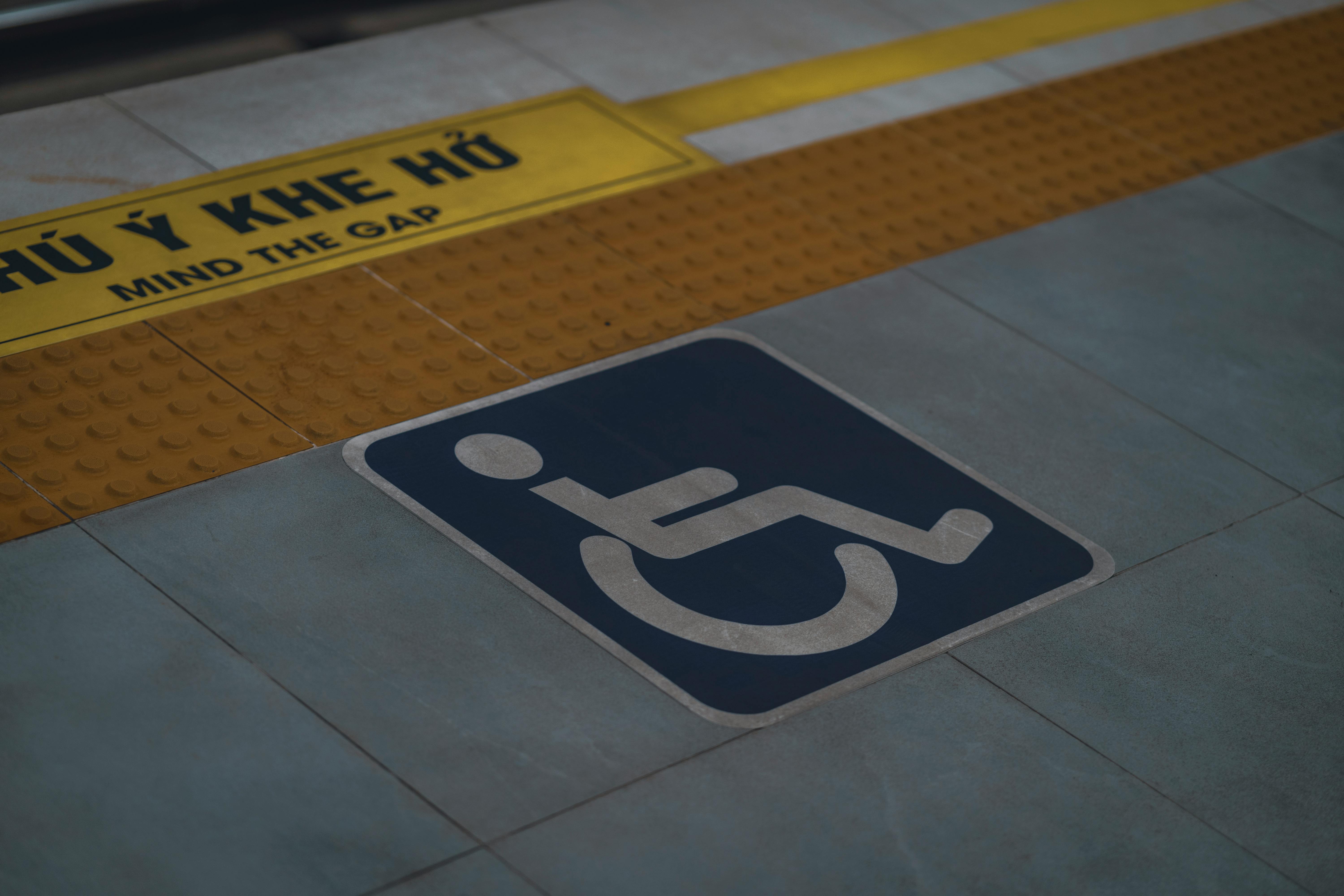 Close-up of handicap symbol and 'Mind the Gap' warning on a station platform.