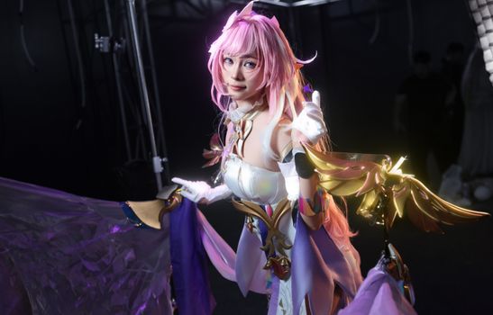 A colorful anime cosplay portrait featuring a character with pink hair and detailed costume.