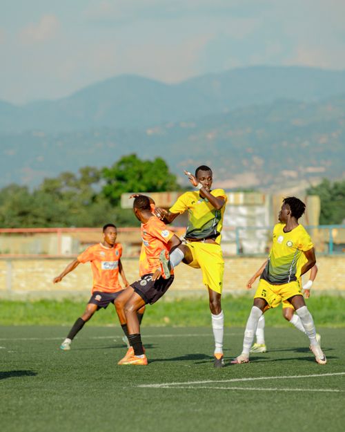 Free Dynamic photo of soccer players in mid-game on a sunny day with mountains in the background. Stock Photo