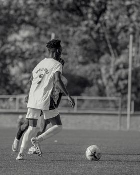 Dynamic black and white photo capturing soccer players in action on the field.