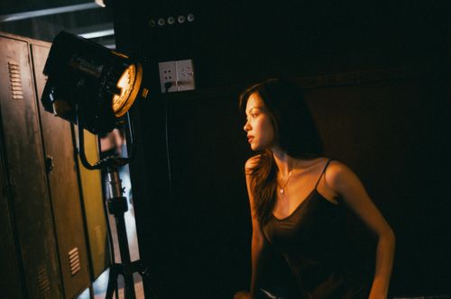 Free A dramatic portrait of a woman illuminated by studio lighting, creating a moody and artistic atmosphere. Stock Photo