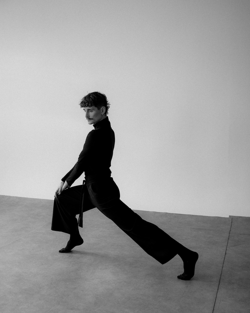 Free A dancer strikes a dynamic pose in a minimalist, black and white setting. Stock Photo