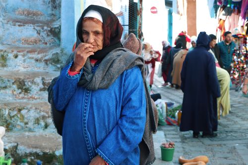 Free Elderly woman wearing traditional attire in a vibrant outdoor market scene. Stock Photo